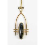 An American yellow metal pendant stamped 9ct, of arched form with central black moonstone, length