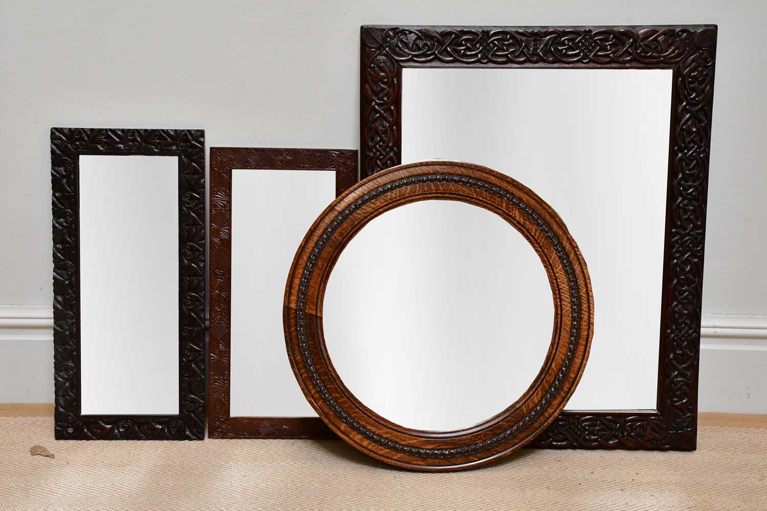 A Macclesfield carved oak framed wall mirror with bevelled plate, approx 83 x 67cm, two similar