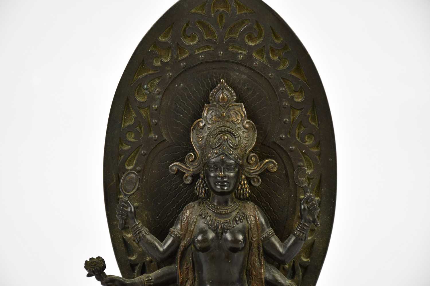 A Chinese bronze figure of a female deity with four arms, with leaf shaped back plate and oval base, - Image 2 of 6