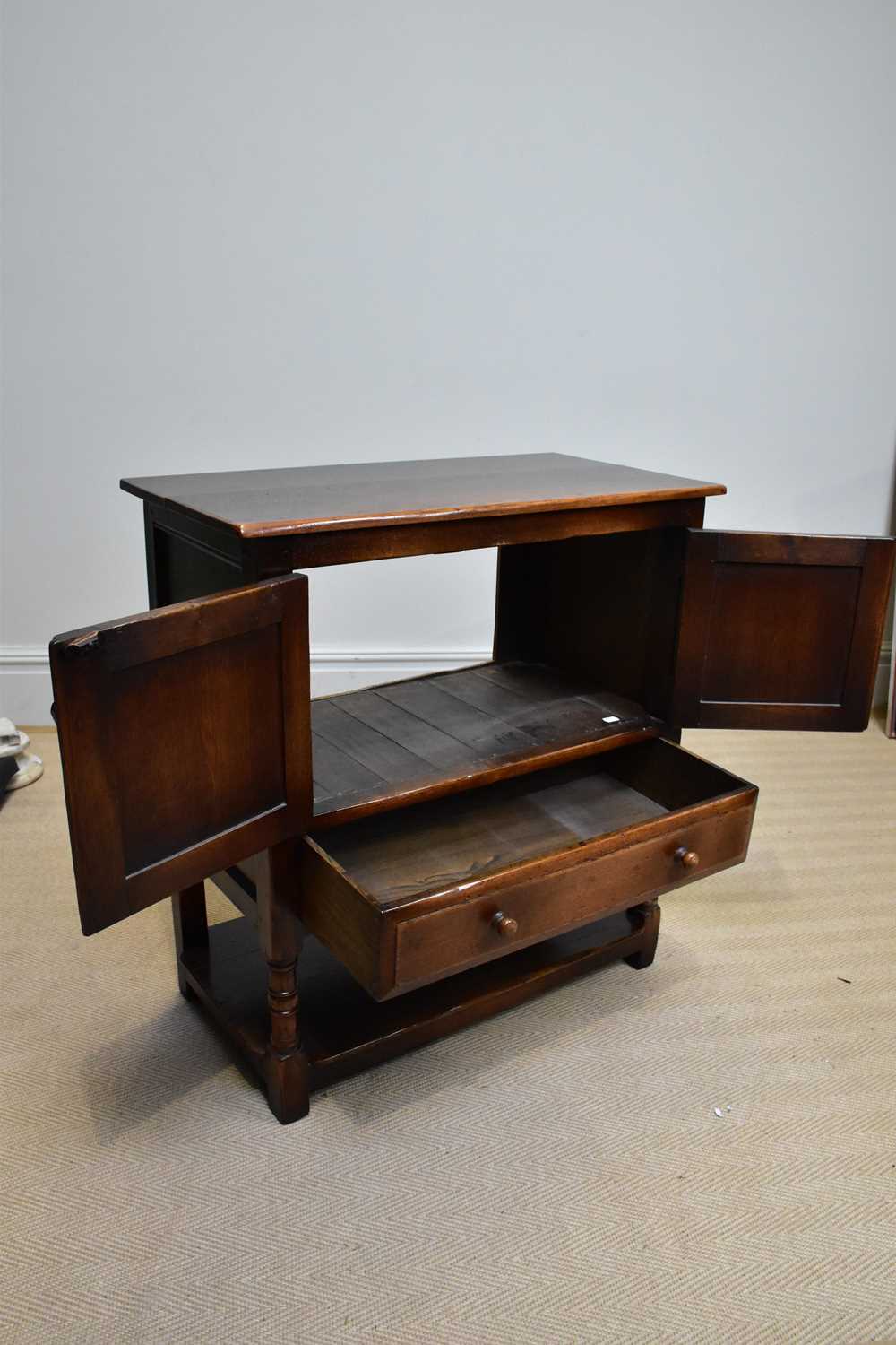 A reproduction oak side cabinet, with two panelled doors above single drawer and undertier, width - Image 2 of 3