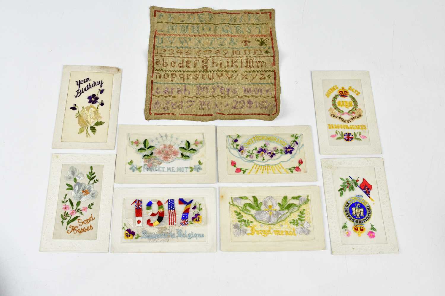 A 19th century alphabet sampler together with a mixed collection of WWI postcards.