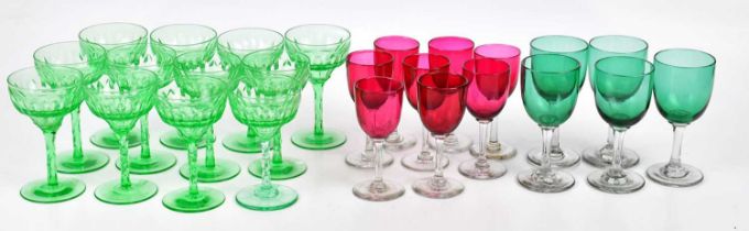 A set of twelve 1930s cut green glass wine glasses, height 12.5cm, with eight late Victorian ruby