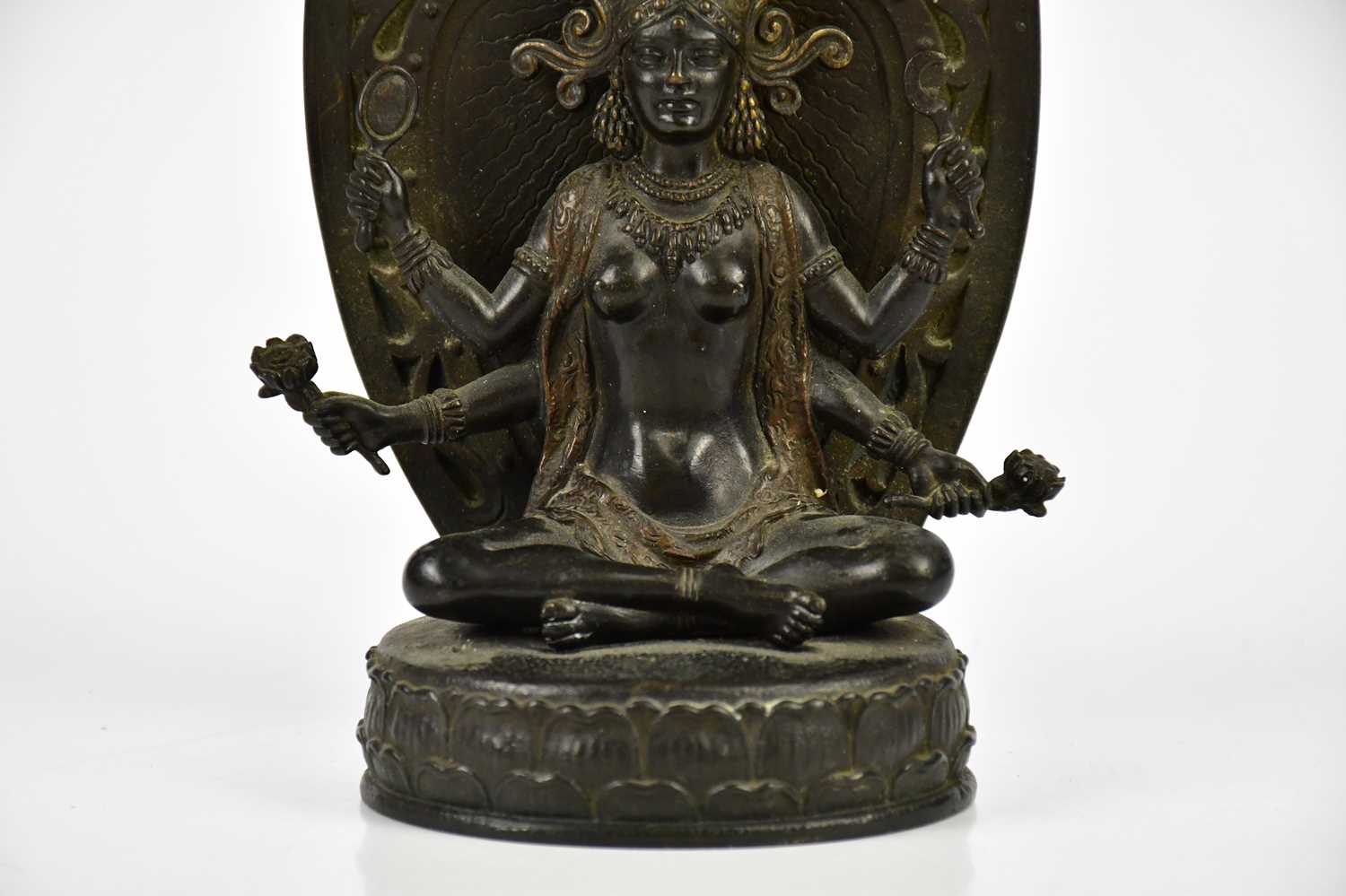 A Chinese bronze figure of a female deity with four arms, with leaf shaped back plate and oval base, - Bild 3 aus 6