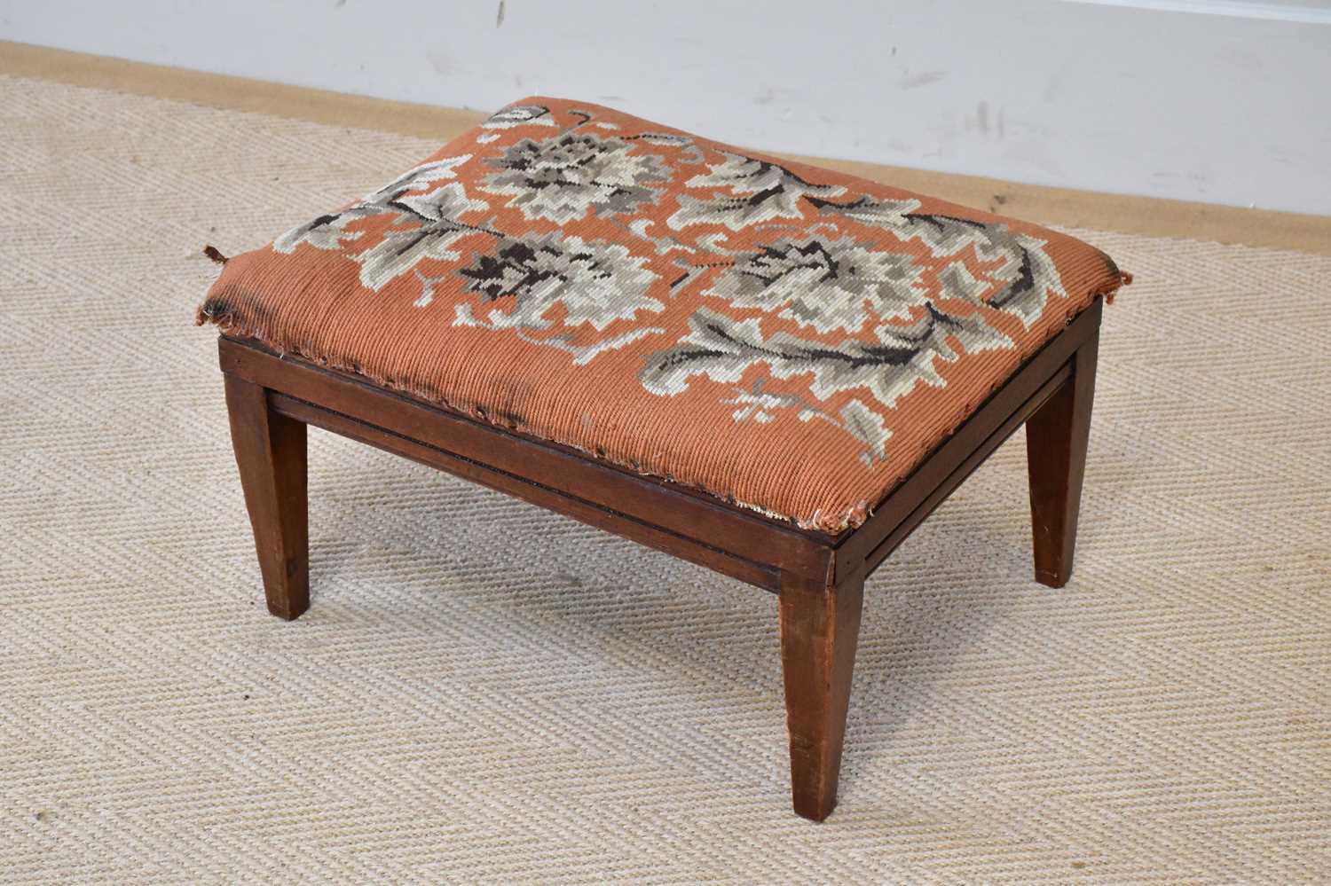 A small rectangular framed footstool with lift-off woolwork top, height 25cm.