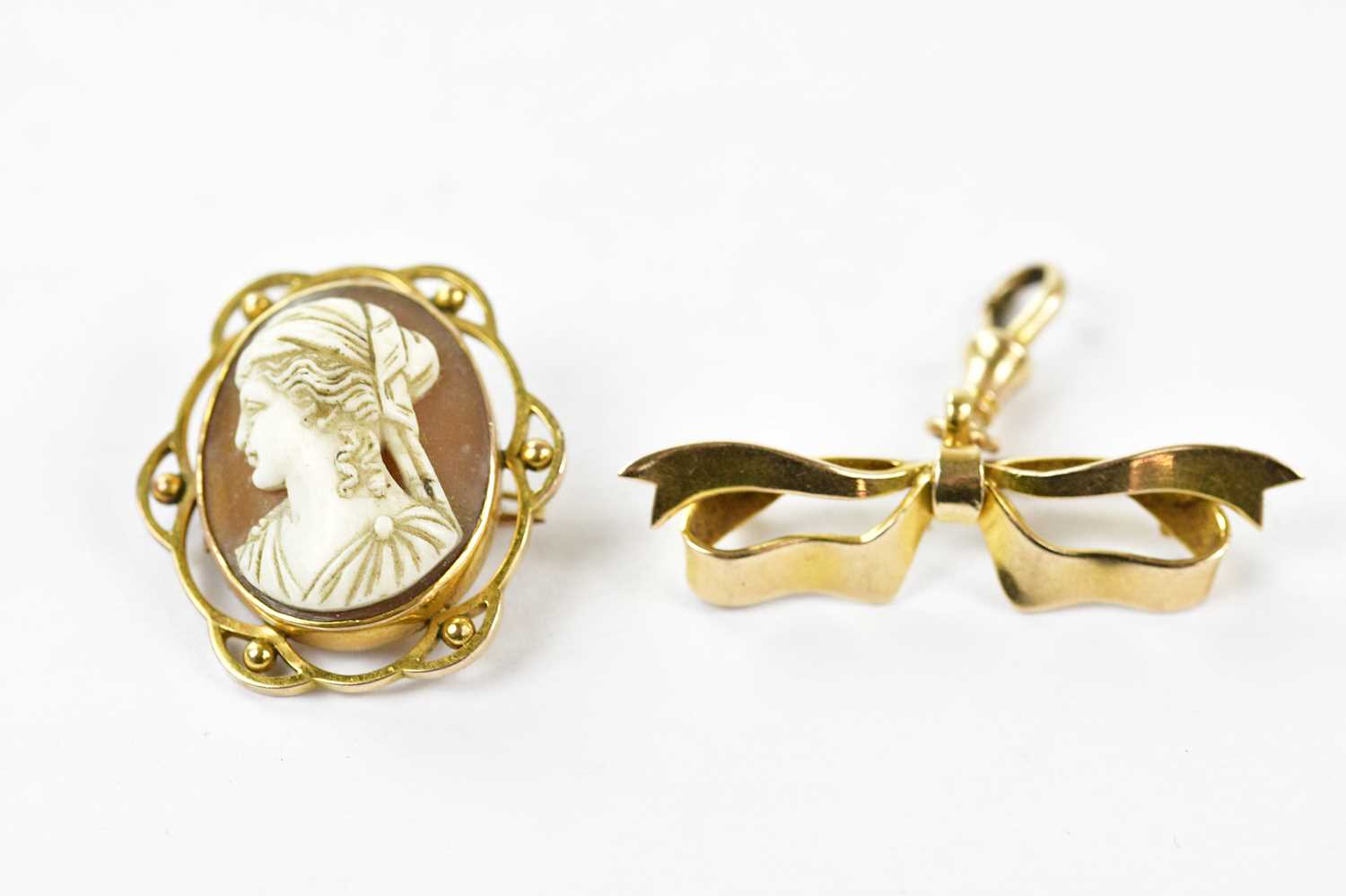 A 9ct gold mounted cameo style brooch and a yellow metal bow brooch, unmarked (2).