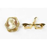 A 9ct gold mounted cameo style brooch and a yellow metal bow brooch, unmarked (2).