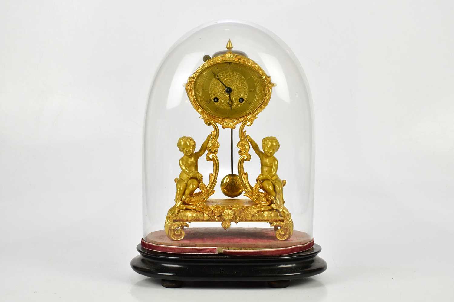 A late 19th century ormolu mantel clock, the oval dial set with Roman numerals on scrolling sabre