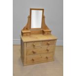 An old stripped pine mirror back dressing table with an arrangement of six drawers on plinth base,