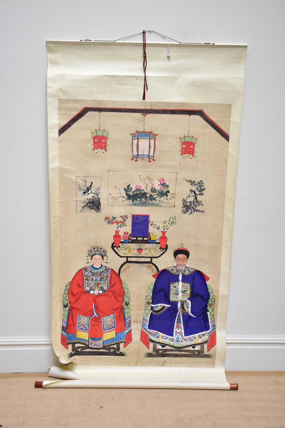 A 19th century Chinese hand painted ancestral portrait depicting elders sitting beside objects,