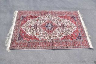 A red ground silk machined carpet with floral geometric central pattern, 305 x 199cm.