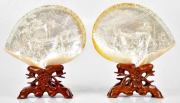 A pair of Chinese mother of pearl shells with carved decoration of figures in garden and landscape