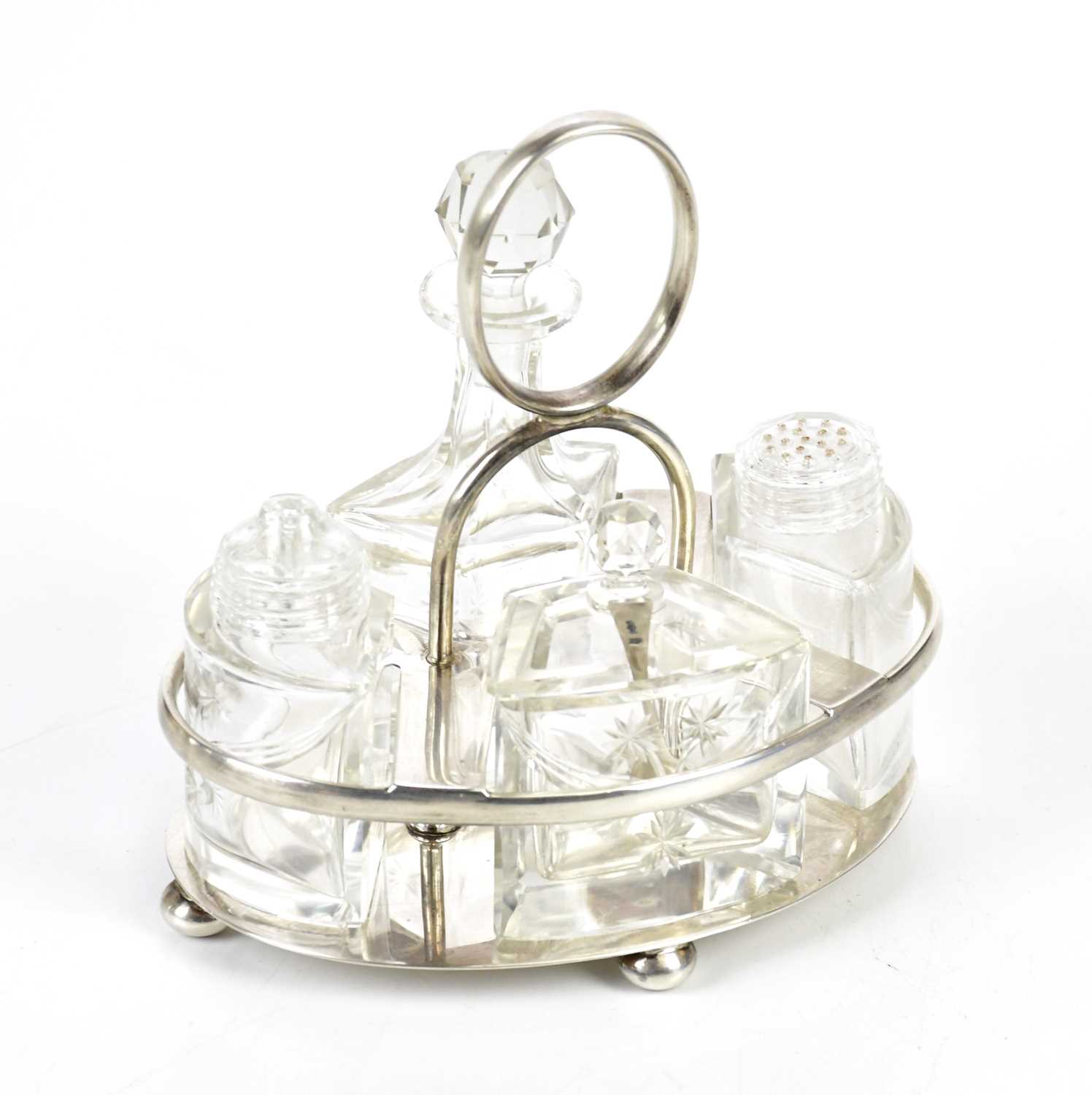 KEMP BROTHERS; a George V hallmarked silver oval cruet stand, stamped London 1927, with four glass