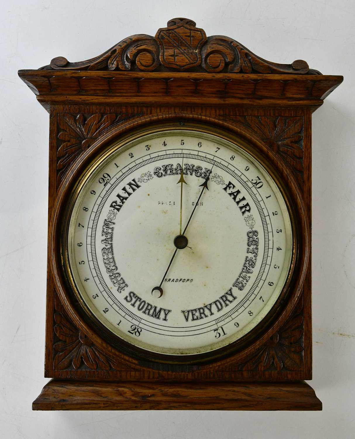 An early 20th century carved oak aneroid barometer, dial signed 'Bradford', 37 x 30cm.