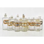 A collection of Victorian clear glass apothecary bottles predominantly with glass labels, various