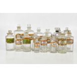 A collection of Victorian and later clear glass pharmaceutical bottles with glass labels, height