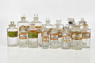 A collection of Victorian and later clear glass pharmaceutical bottles with glass labels, height