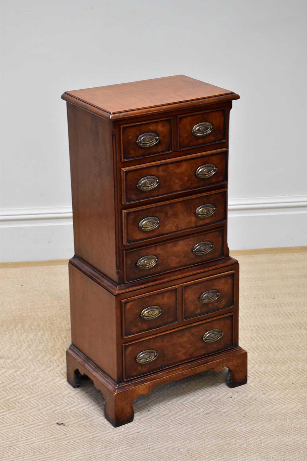 A reproduction small sized walnut chest of six drawers, on bracket feet, width 40cm, depth 28cm,