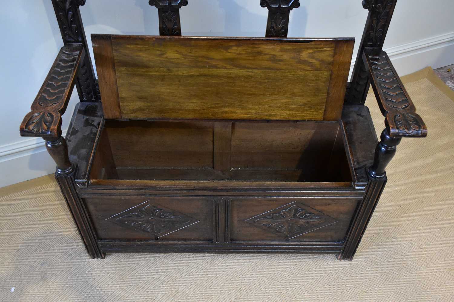 An early 20th century carved oak hall settle, with raised back and hinged seat, width 107cm, - Image 2 of 3