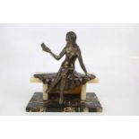 An Art Deco style spelter figure of seated girl holding a bird, on marble base, height 32cm.