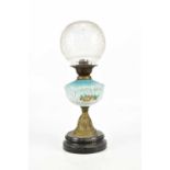 An early 20th century oil lamp, with frosted glass globular shade above the blue and milk glass