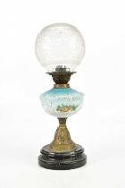 An early 20th century oil lamp, with frosted glass globular shade above the blue and milk glass