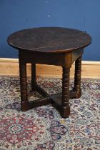 A James I oak credence table with an oval flat top and triangular frieze on bobbin turned legs