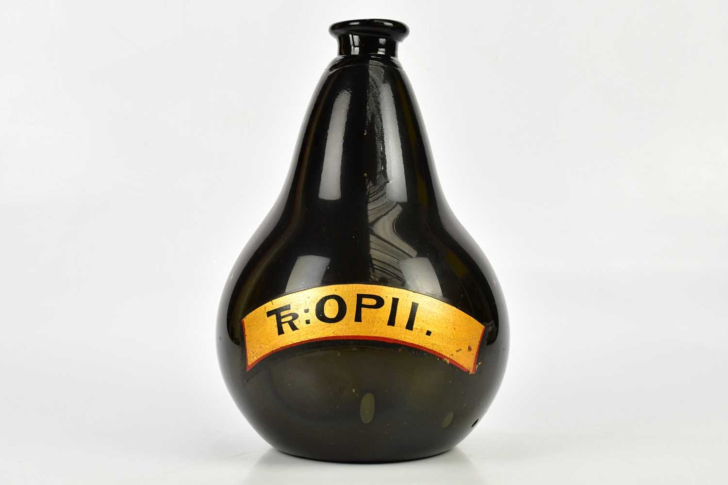 A Victorian black glass pharmaceutical bottle with gilt label 'TR:OPII', height 30cm. Condition
