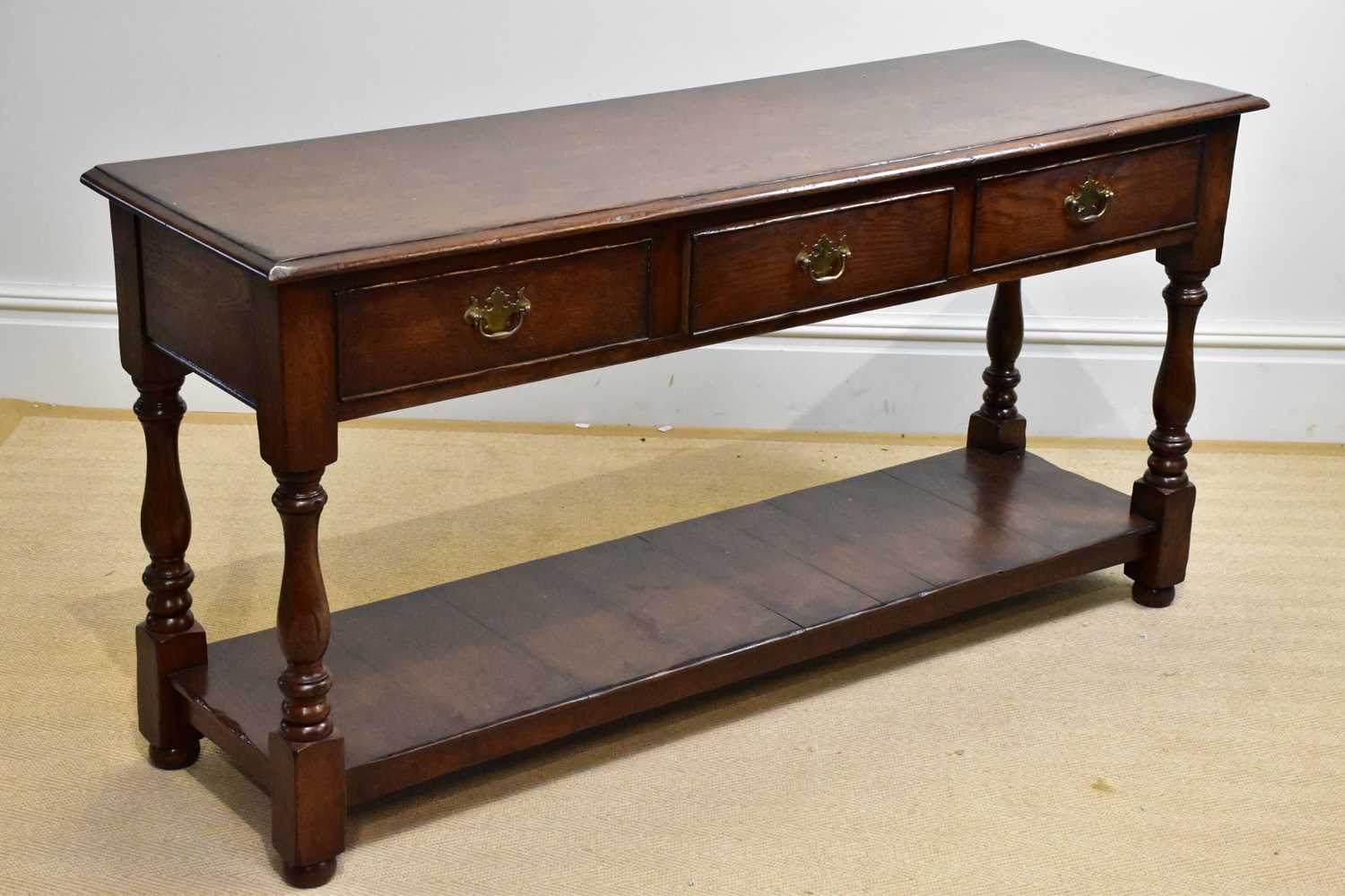 A 20th century three drawer oak dresser base, height 72cm, width 150cm, depth 46cm.
