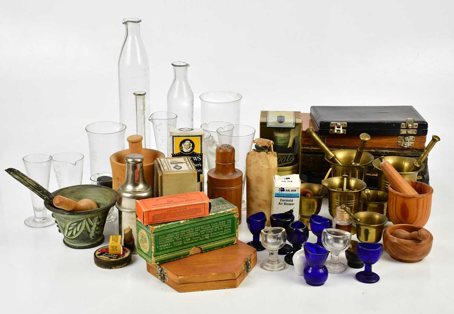 A collection of pharmaceutical items including test tubes, measuring glasses, eye baths, pestles and