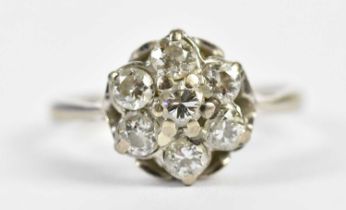 An 18ct white gold seven stone diamond flowerhead ring, each stone weighing approx. 0.20cts, size K,