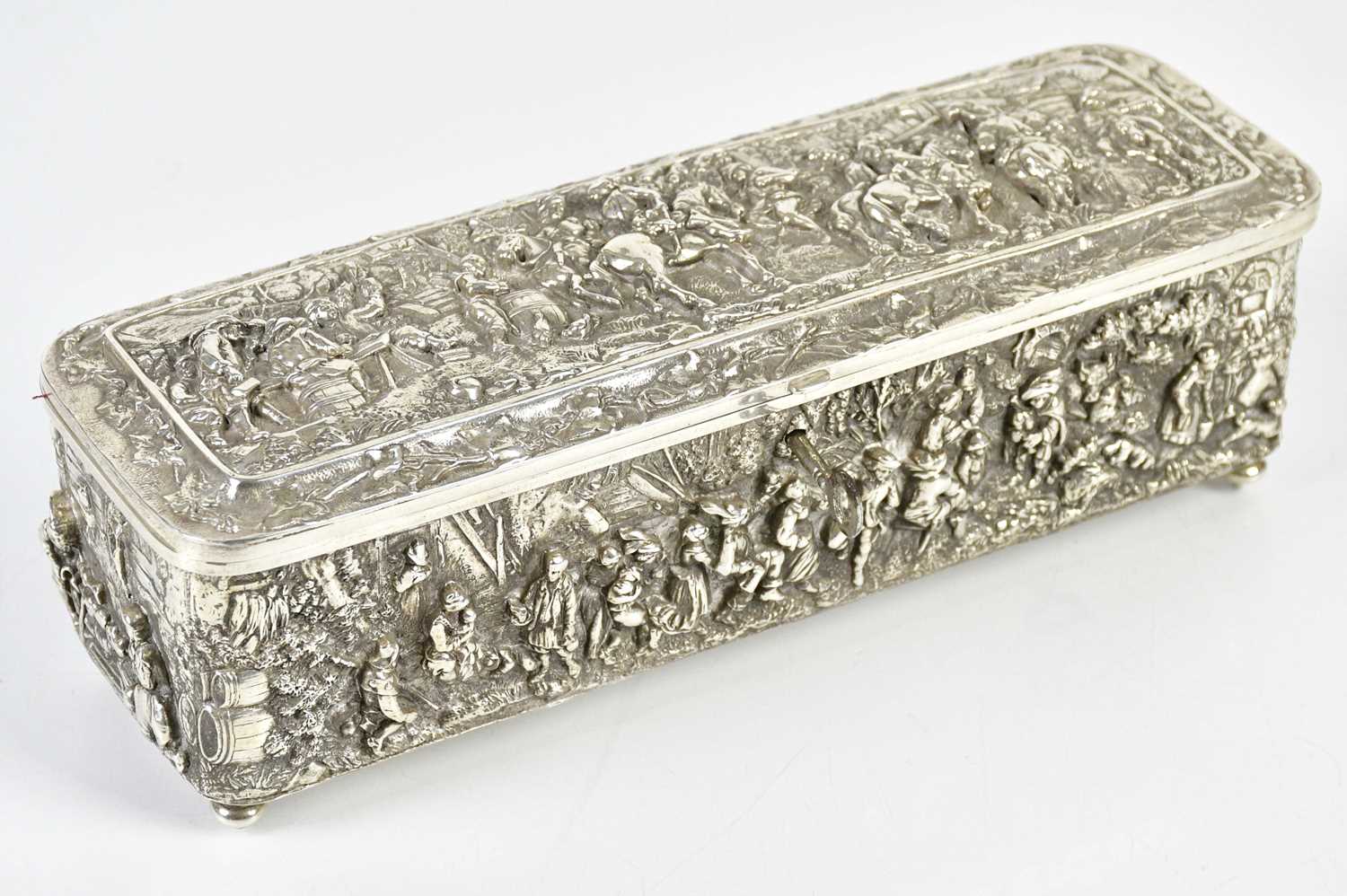 A Continental white metal casket of rectangular form embossed with tavern scenes and figures on
