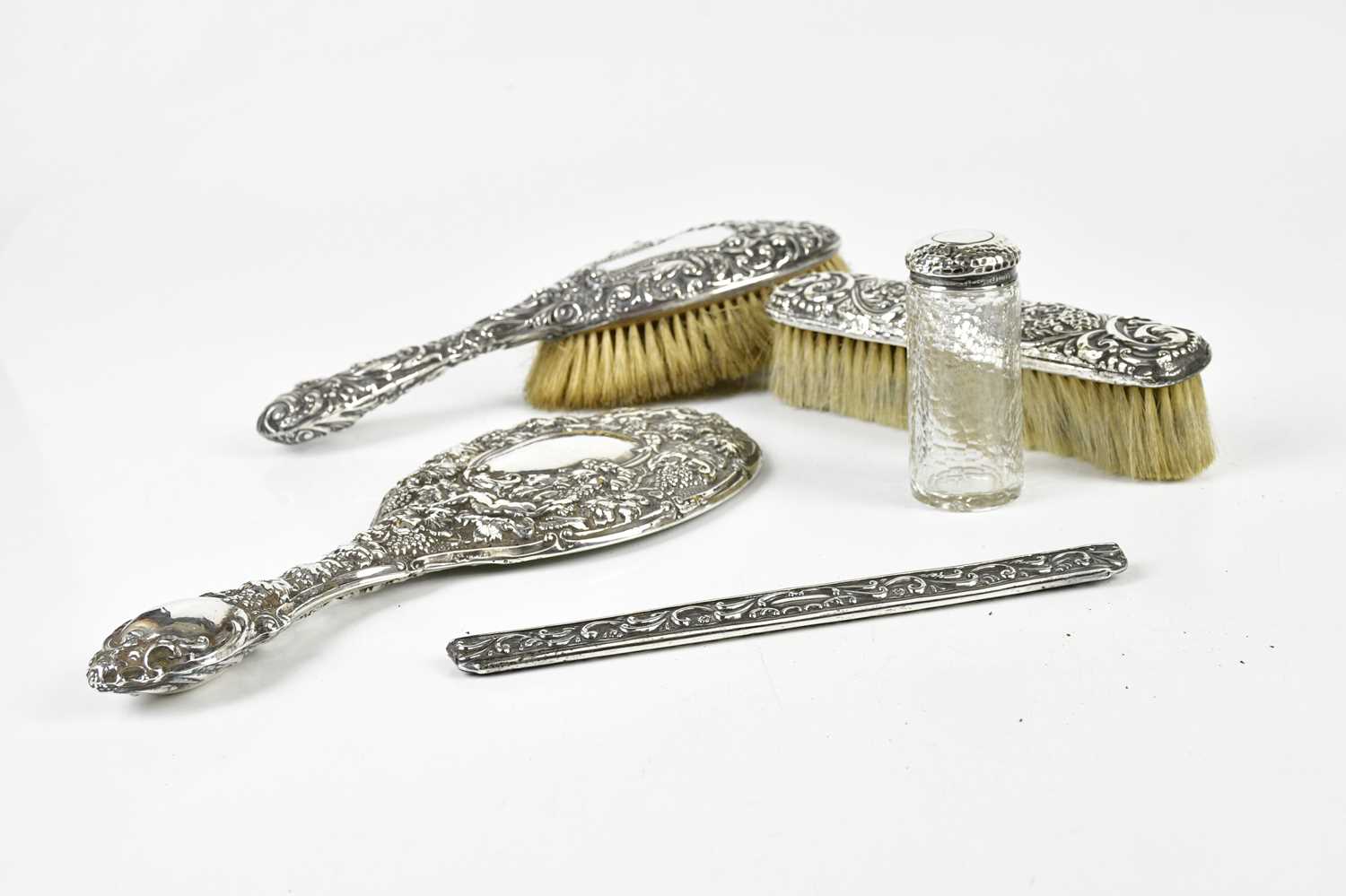 A matched hallmarked silver four piece dressing table set and glass dressing table bottle with