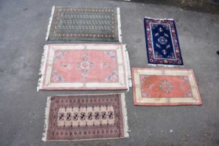 Five decorative modern rugs including a green ground example with elephant foot decoration, two