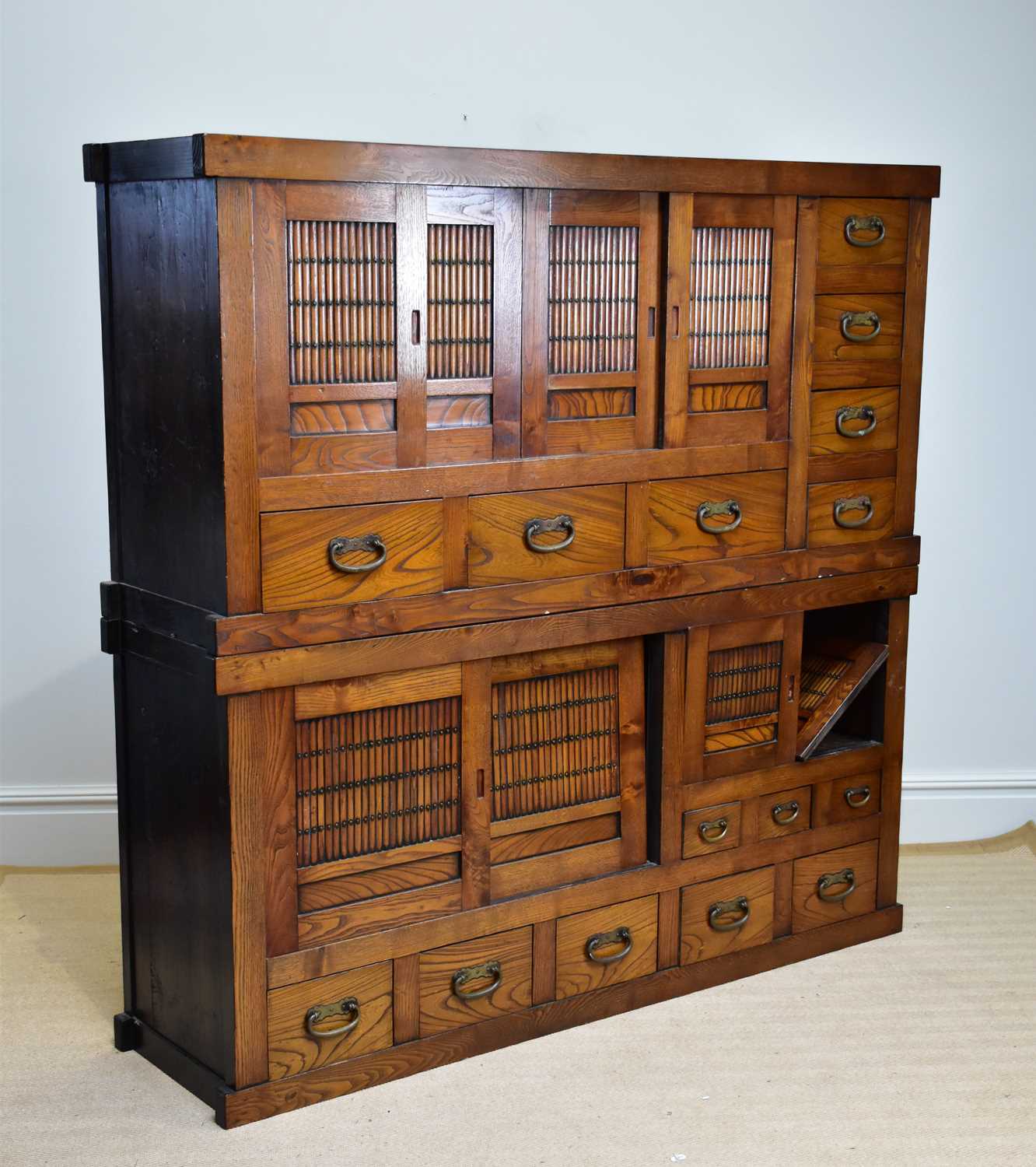 A 20th century Chinese elm cabinet of large proportions with an arrangement of sliding doors and