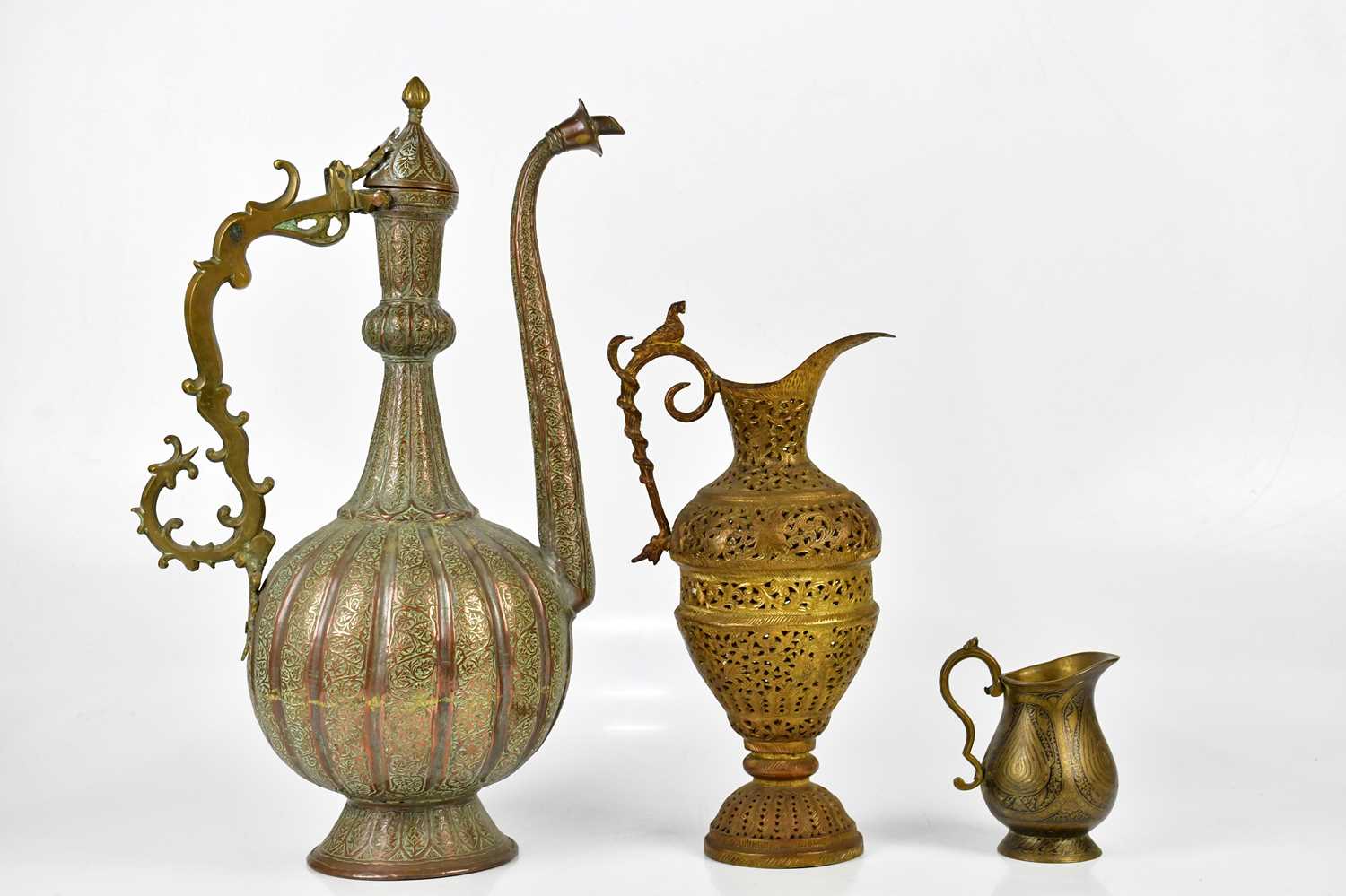 A large Persian ewer, height 49cm, together with a two smaller jugs.