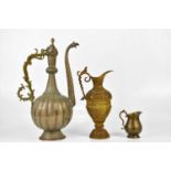 A large Persian ewer, height 49cm, together with a two smaller jugs.