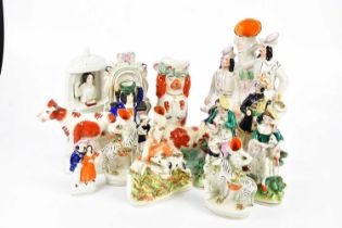 A collection of Staffordshire figures to include 'Robin Hood', 'Wesley', hound chasing deer, cows,