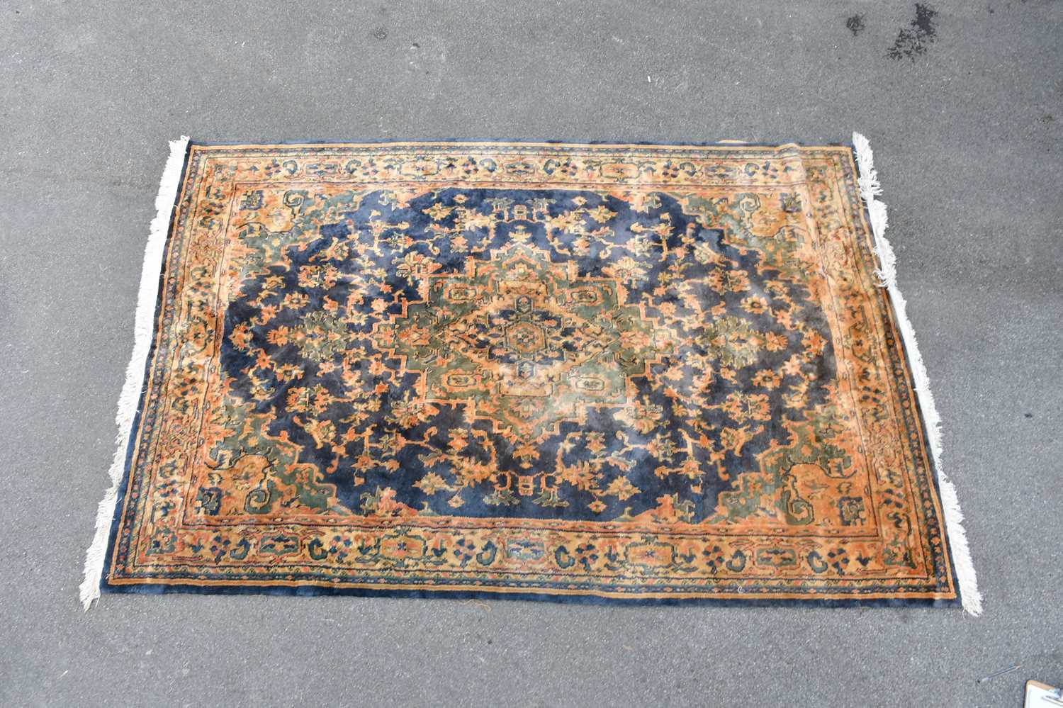 A decorative eastern style rug with floral decoration on blue and orange ground 270cm x 182cm.