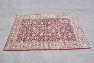 A red ground wool carpet with floral geometric central design, 230 x 157cm.