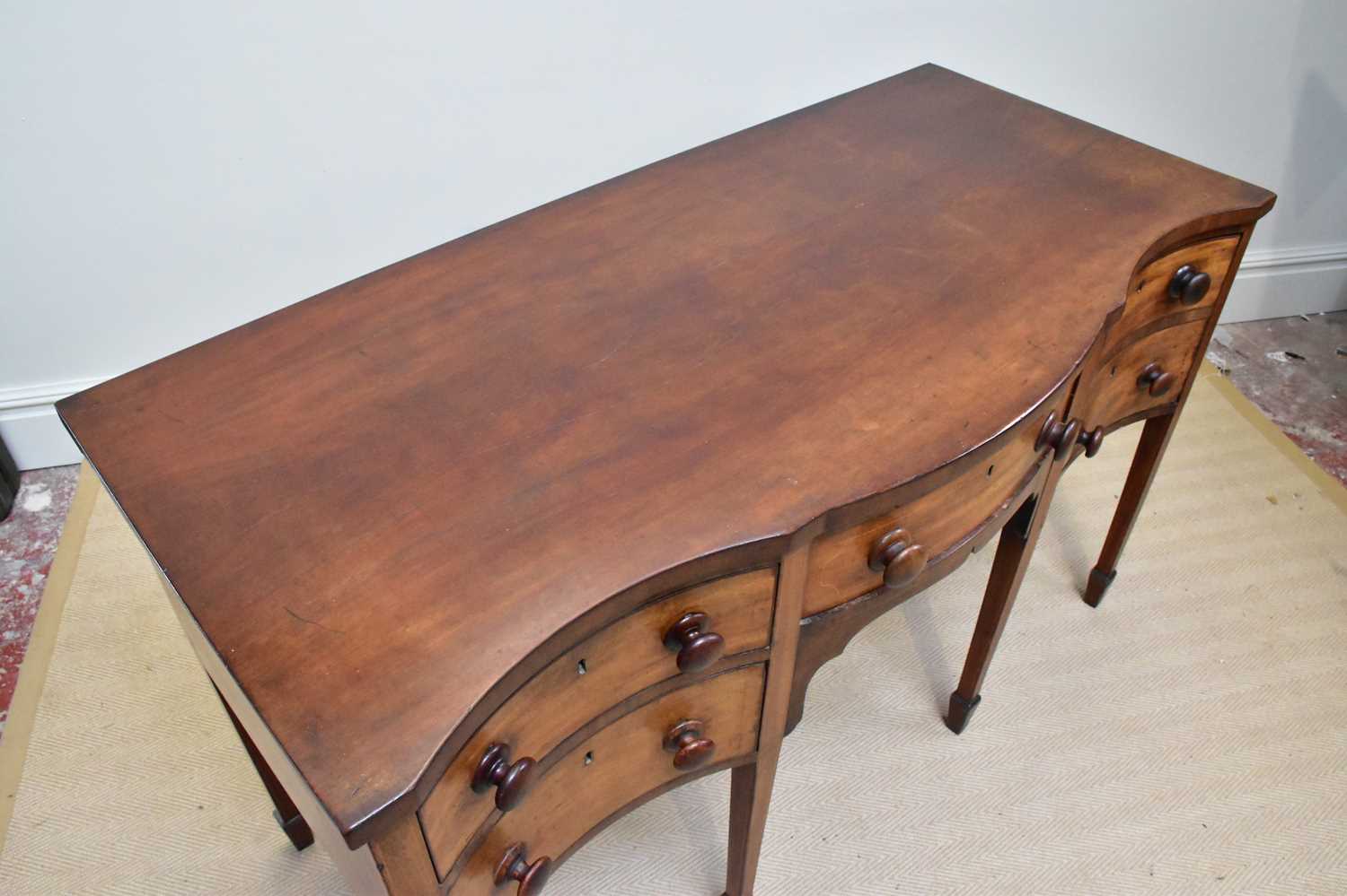 A late George III serpentine mahogany sideboard with three short drawers and one deep drawer on - Image 2 of 4