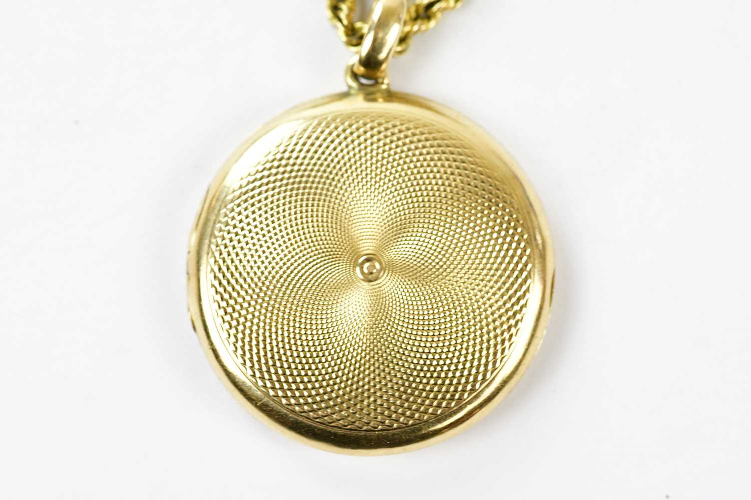 A 15ct yellow gold locket with engine turned decoration suspended on a yellow metal rope link chain, - Image 2 of 4