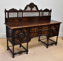 An early 20th century oak sideboard in the Carolean style with cane work raised back with arched top