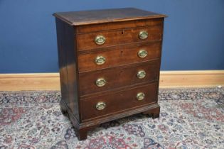 A late George III oak chest, with four graduated long drawers with oval brass handles decorated with