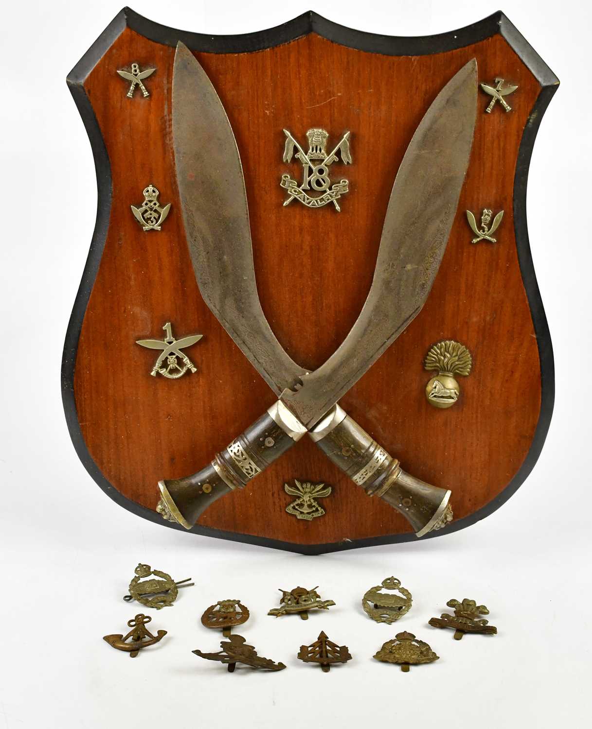 Two Gurka kukri knives mounted onto a shield shaped back plate with badge for 18th Cavalry and