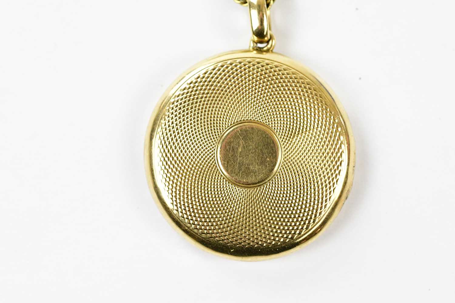 A 15ct yellow gold locket with engine turned decoration suspended on a yellow metal rope link chain, - Image 3 of 4