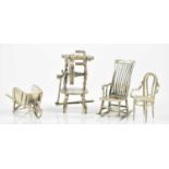 A group of miniature items including rocking chair, spinning wheel, elbow chair and a wheelbarrow,