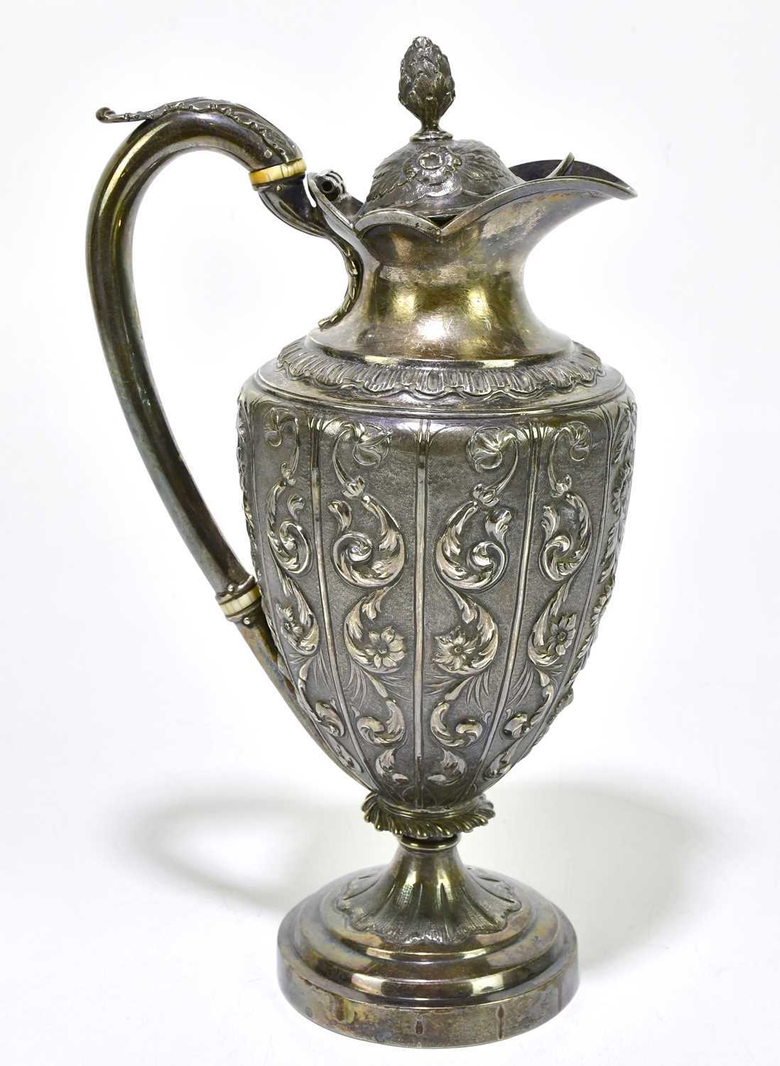 A Georgian hallmarked silver wine ewer, with cast and repoussé decoration of scrolls and foliates,