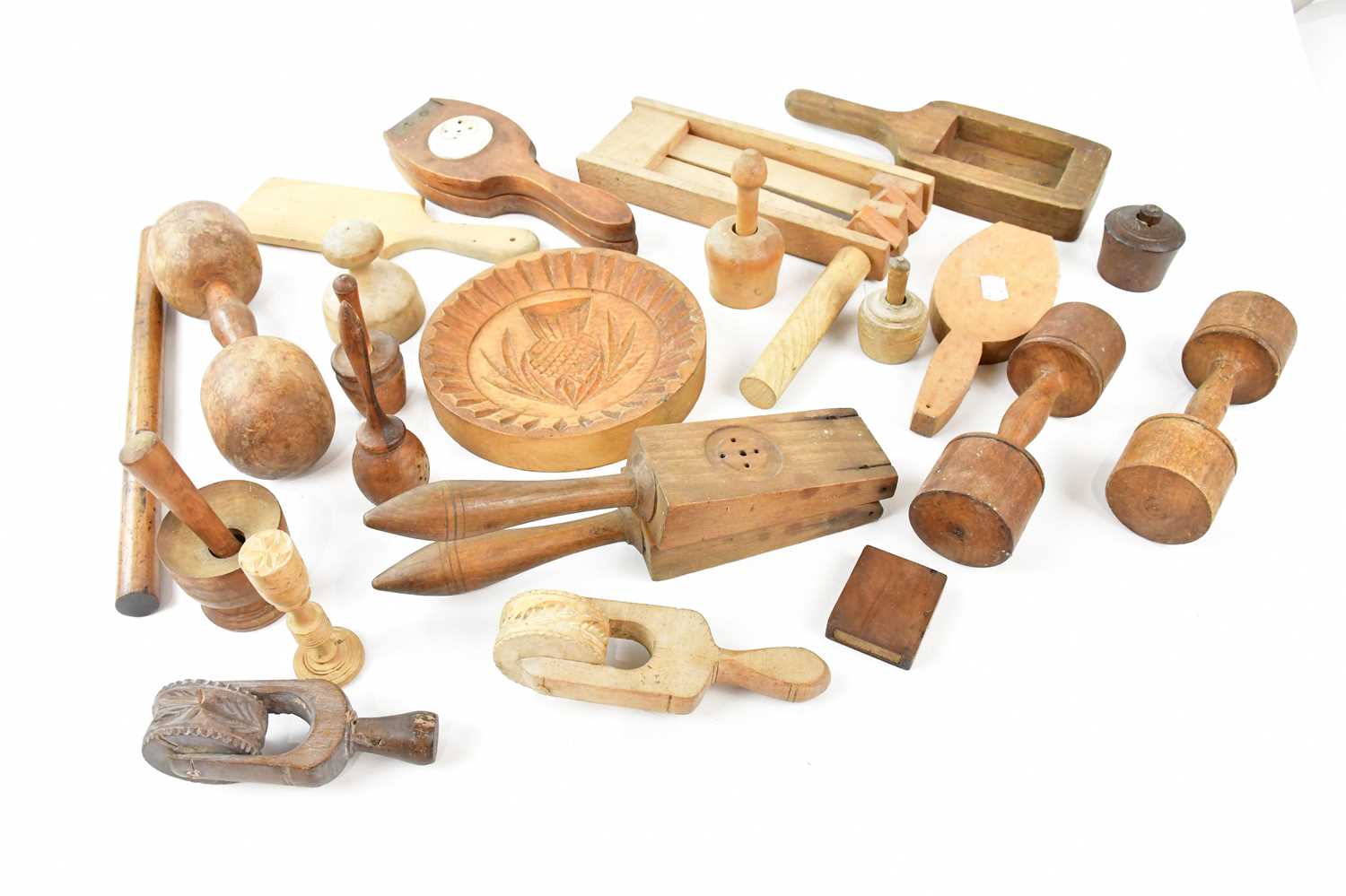 A collection of 19th/early 20th century treen kitchenalia including presses, butter and biscuit