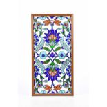 Two 20th century Iznik tiles with floral decoration in a frame, overall 42 x 22cm