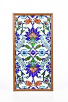 Two 20th century Iznik tiles with floral decoration in a frame, overall 42 x 22cm